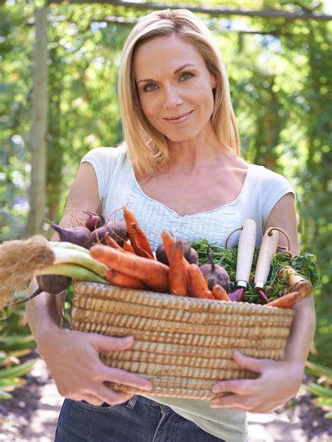 Celebrating A Bountiful Harvest A Woman Holding A Basket Of Fresh Vegetables Stock Photo