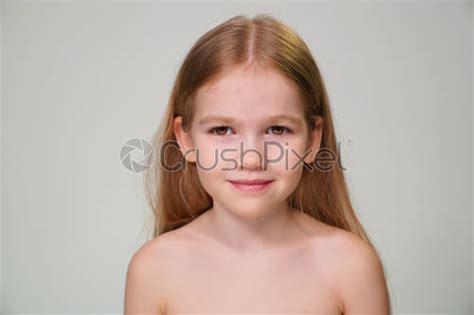 Ein kleines Mädchen mit blonden Haaren gegen eine wei Foto vorrätig Crushpixel