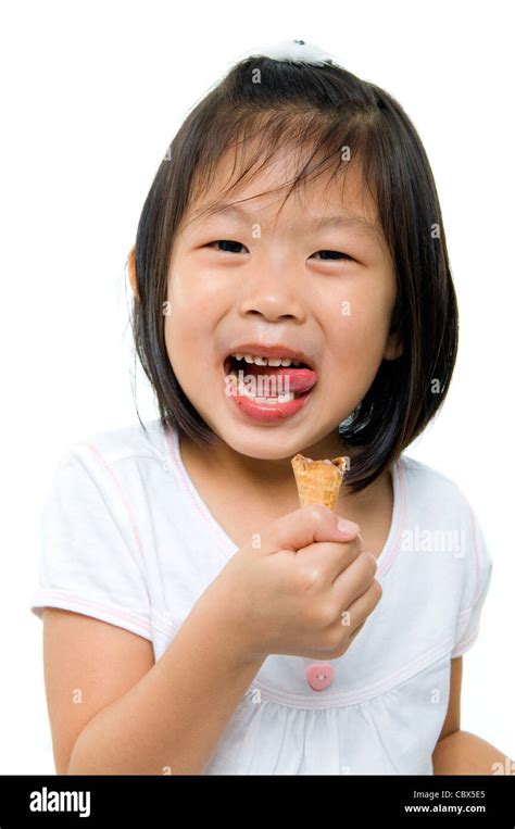 Poco De Asia Chica Lamiendo Sus Labios Con Un Cono De Helado En La Mano Fotografía De Stock Alamy