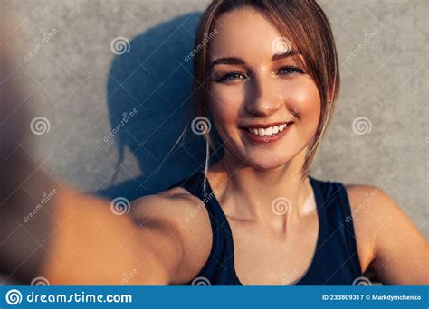 Beautiful Athletic Fitness Woman Taking Selfie Photographing Herself Against Gray City Wall