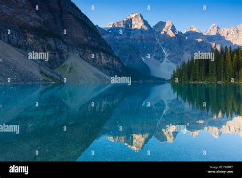 Mountains Reflected In Glacial Water Of Moraine Lake In The Valley Of