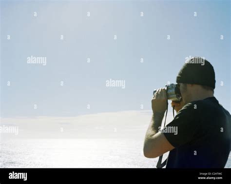 Man Photographing Ocean View With Camera Stock Photo Alamy