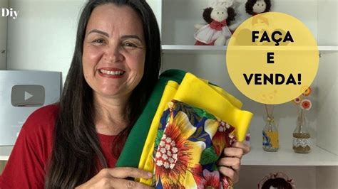 A Woman Holding Up A Yellow Box With Flowers On It And The Words Faca E Venda In Spanish