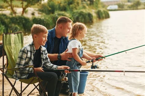 Sentados Juntos Padre Con Hijo E Hija Pescando Al Aire Libre En Verano