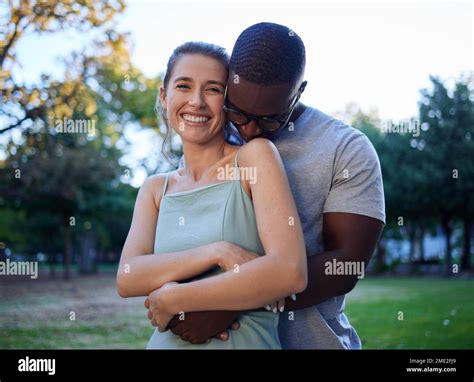 Happy Interracial Couple Hug And Smile For Love Care Or Bonding Together In The Nature Park