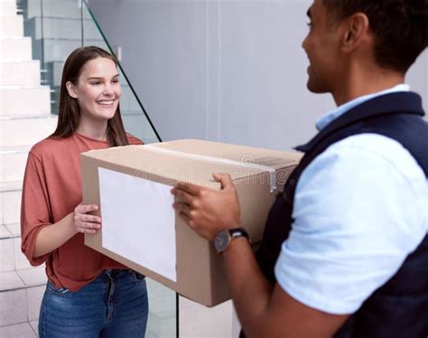 Im Glad That I Caught You Shot Of A Woman Accepting Her Delivery From The Delivery Man Stock