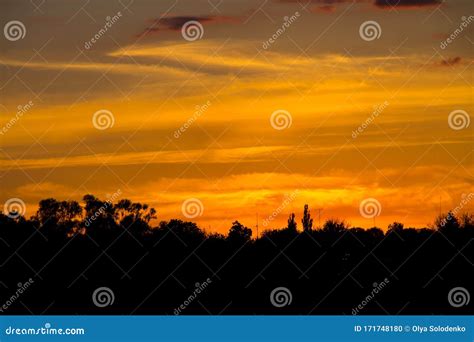 Orange Sunset Over Silhouettes Of Village And Trees Stock Photo Image