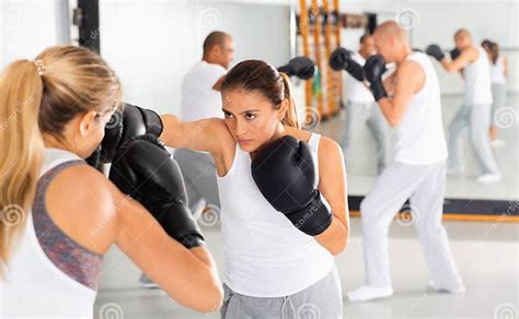 Two Women In Boxing Gloves Have Boxing Fight In The Gym Stock Photo