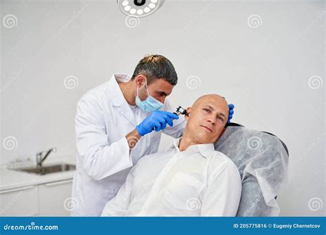 Doctor Ent Checking Ear With Otoscope To Man Patient At Hospital Stock