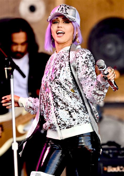 A Woman With Purple Hair Singing Into A Microphone