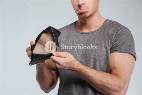 Cropped Image Of A Sad Casual Man Showing Empty Wallet Over White