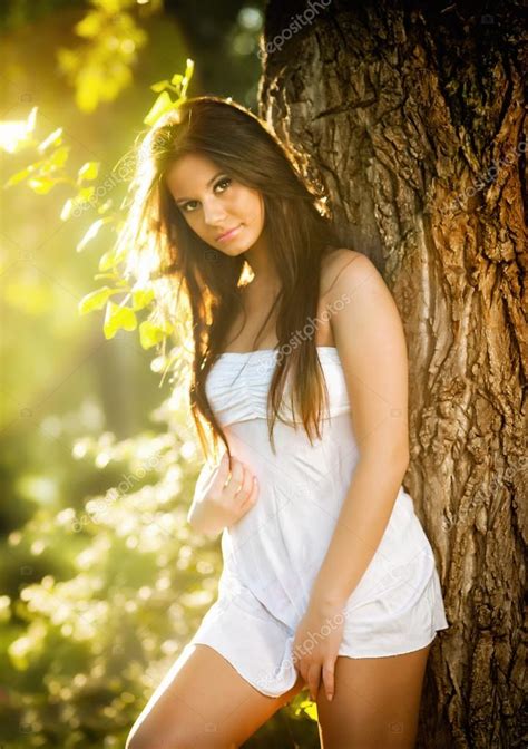 Attractive Young Woman In White Short Dress Posing Near A Tree In A Sunny Summer Day Beautiful