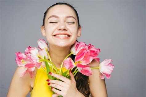 Premium Photo Beautiful Young Woman Holds A Bouquet Of Pink Flowers