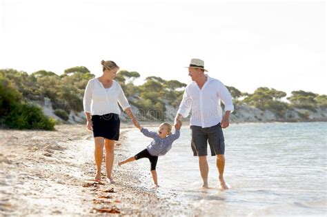 Madre Joven Y Padre Felices Que Caminan Con La Pequeña Hija En La Playa