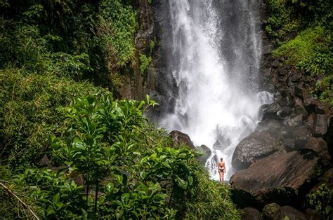 woman standing in front of trafalgar falls dominica everything everywhere places to travel