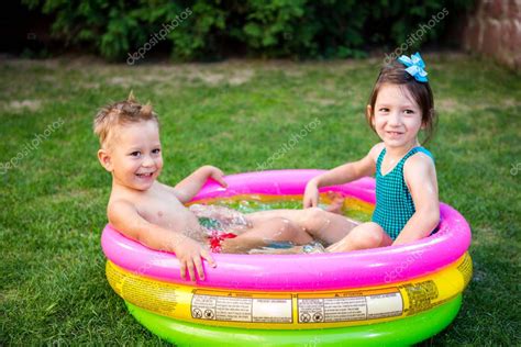 Dos Hermanitos Jugando Y Chapoteando En La Piscina El Caluroso Día De