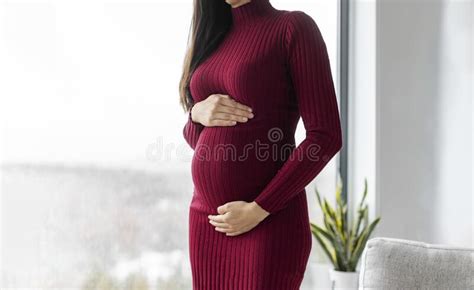 pregnant woman profile holding her belly in red dress beautiful model for pregnancy maternity