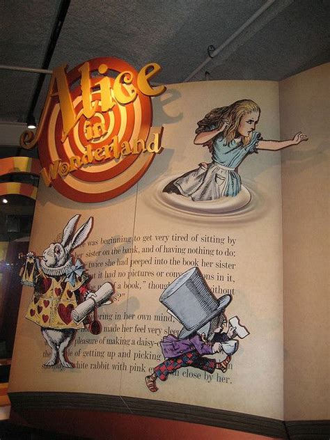 An Open Book With Images Of Alice And The Wonderland Land On It S Cover