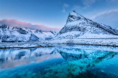 Beautiful Snow Covered Mountains And Blue Sky Reflected In Water Stock