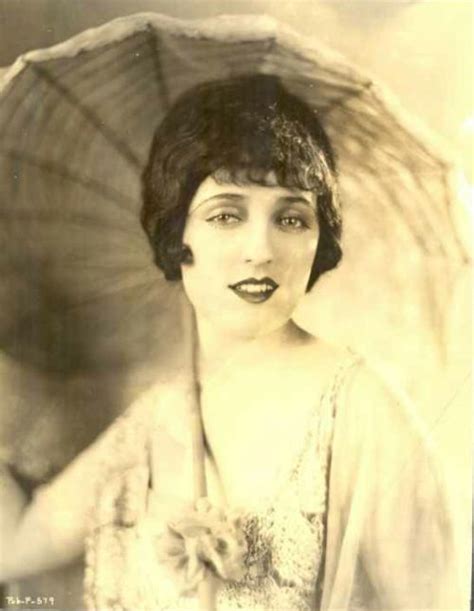 An Old Black And White Photo Of A Woman Holding An Umbrella