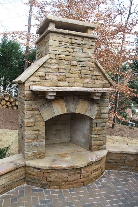 Stacked Stone Outdoor Fireplace With Seating Wall And