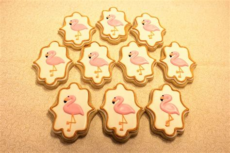 Decorated Cookies With Pink Flamingos And White Frosting On A Beige Tablecloth Background