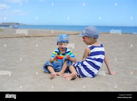 Zwei Kinder Sitzen Am Strand Stockfotografie Alamy