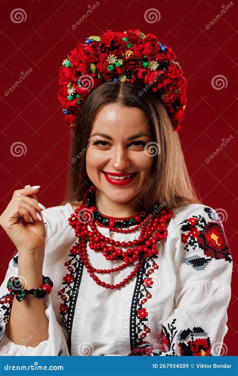 portrait of ukrainian woman in traditional ethnic clothing and floral red wreath on viva magenta