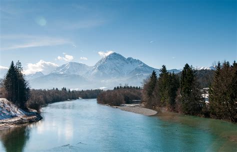 A Scenic Landscape With A Bending River And Snow Capped Mountains In