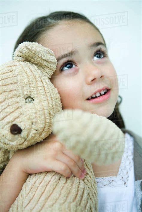 Little Girl Holding Teddy Bear Looking Up Portrait Stock Photo