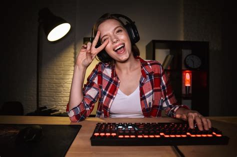 Premium Photo Excited Woman Gamer Sitting At The Table Playing