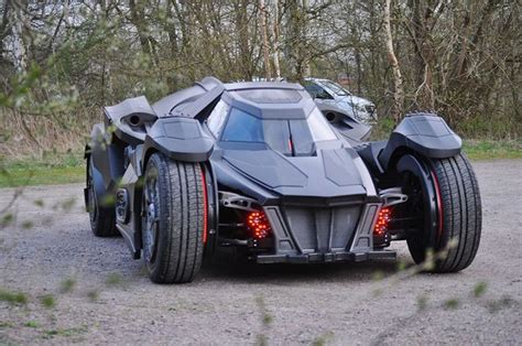 The Batmobile Is Parked In Front Of Some Trees