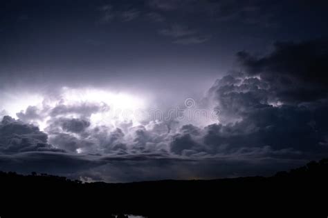 Strong Lightning In And Behind Big Towering Thunderclouds Stock Photo