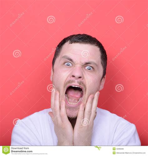 Portrait Of Angry Man Screaming Against Red Background Stock Photo
