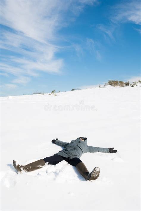 Girl Making Snow Angels In An Amazing Sunny Snowy Day Stock Photo