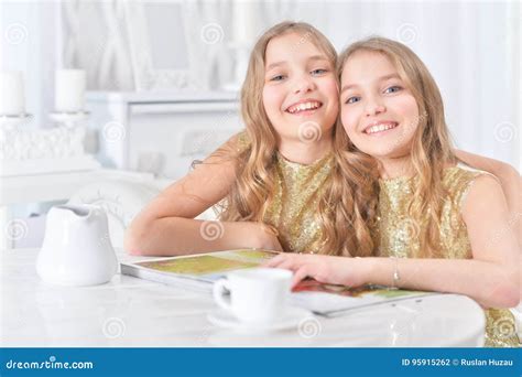 Cute Twin Sisters With Modern Magazine Stock Photo Image Of Loving