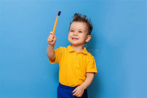 Happy Child Kid Boy Brushing Teeth With Toothbrush On Blue Background