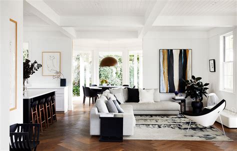A Living Room Filled With White Furniture And Lots Of Wood Flooring