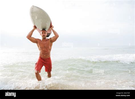 Image Of A Concentrated Strong Young Handsome Man Surfer With Surfing