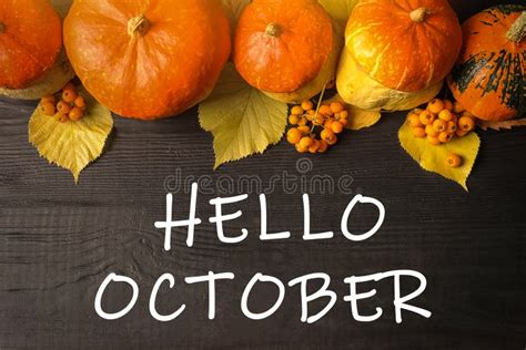Hello October Text Pumpkins And Autumn Leaves On Wooden Background