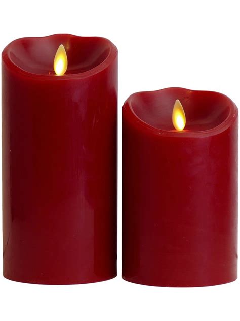 Two Red Candles Sitting Next To Each Other