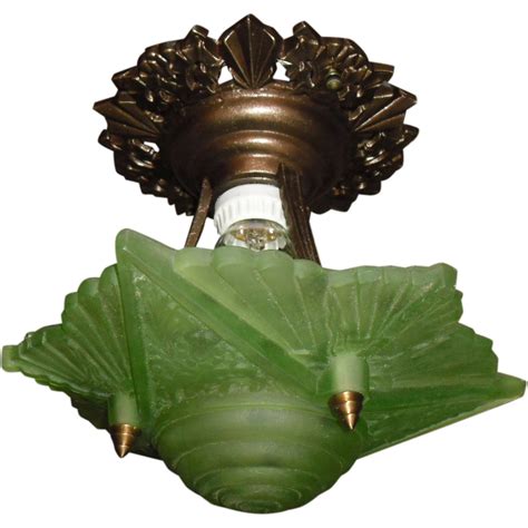 A Green Glass Light Fixture With A Wine Bottle In The Middle And An