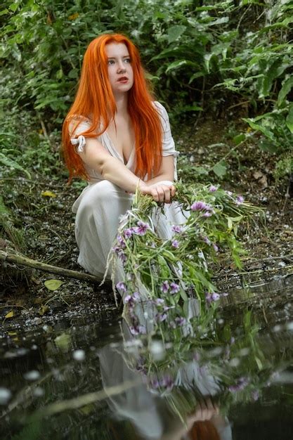 młoda dziewczyna w białej sukni z wieńcem w dłoniach siedzi na brzegu jeziora dzień iwana kupały