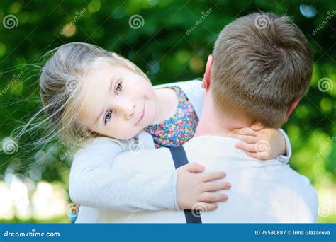 Niña Adorable Feliz Que Abraza Abrazando A Su Padre Imagen De Archivo