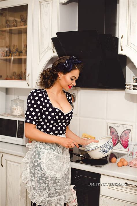 A Woman Is Cooking In The Kitchen While Wearing An Apron And Polka Dot Shirt With Ruffles