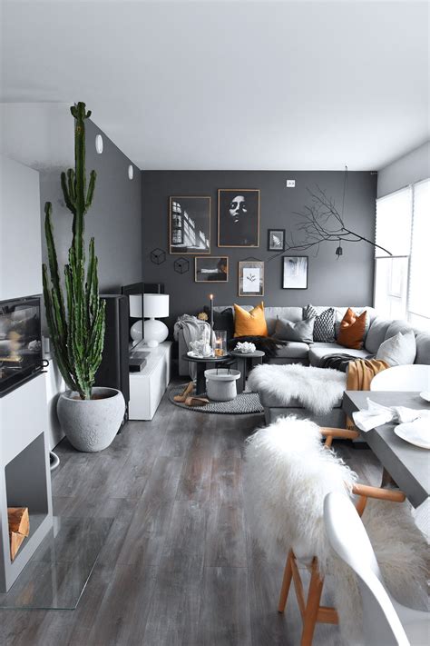 These luxury living room ideas also prove that careful planning and a commitment to creativity can go a long way. Dark grey wall living room with indoor plants and orange ...