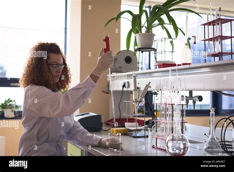Teenage Girl Holding Pipette While Practicing Chemistry Experiment At