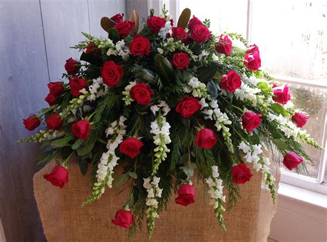 The blanket of flowers that covers the top of the casket, these arrangements are primarily sent by the spouse or immediate family. Red and White Casket Spray | Michler's Florist | Lexington, KY