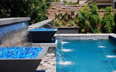 There is nothing like a lit up pool in the backyard at night, with a couple lit up streams of water arching into the pool. Aquanetic Pools And Spas Custom Waterfall Pool Water ...