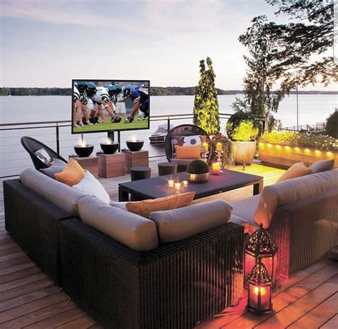 An Outdoor Deck With Wicker Furniture And Lit Candles On The Table